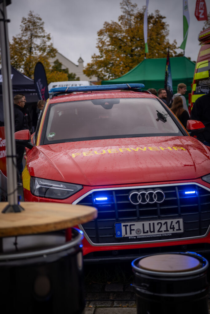 Rotes Feuerwehr-Kommandofahrzeug mit blauer Sondersignalanlage und Schriftzug Feuerwehr